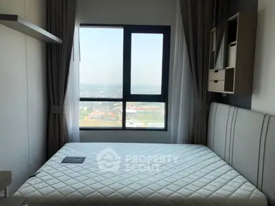 Modern bedroom with large window offering stunning city view, featuring sleek furniture and neutral tones.