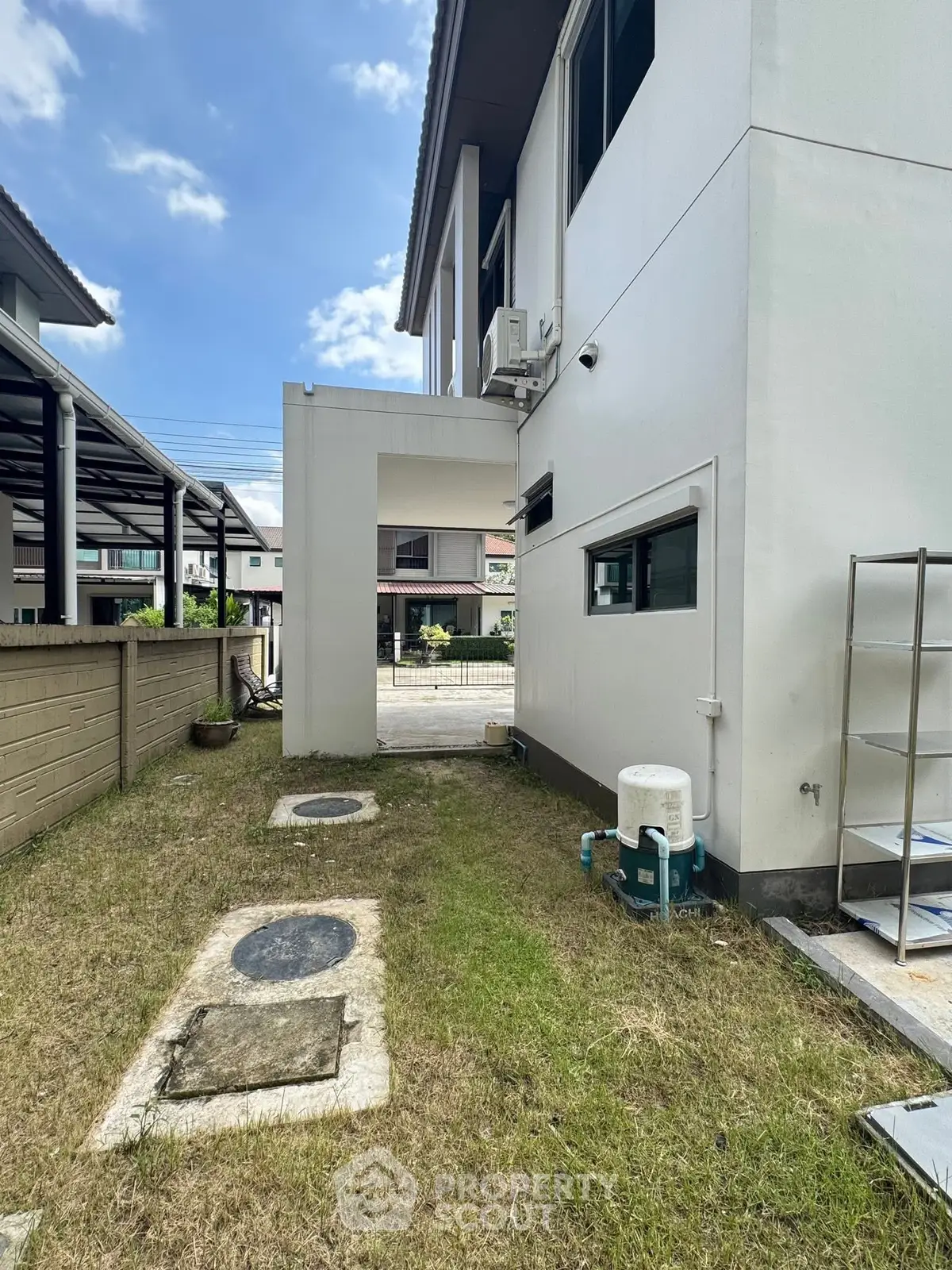 Spacious side yard of a modern house with potential for landscaping or outdoor activities.