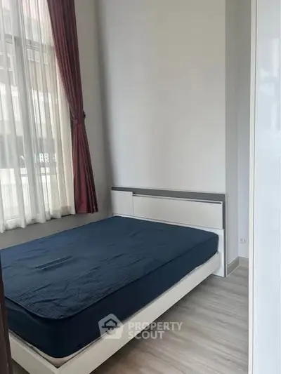 Cozy bedroom with natural light and modern furnishings, perfect for a restful retreat.