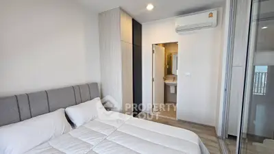 Modern bedroom with ensuite bathroom and air conditioning in stylish apartment.