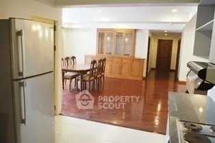 Spacious open layout kitchen and dining area with wooden flooring and modern appliances.