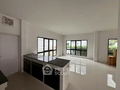 Spacious modern living room with large windows and sleek black countertops