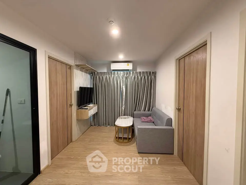 Modern living room with sleek design, featuring a cozy sofa, stylish coffee table, and wall-mounted TV.