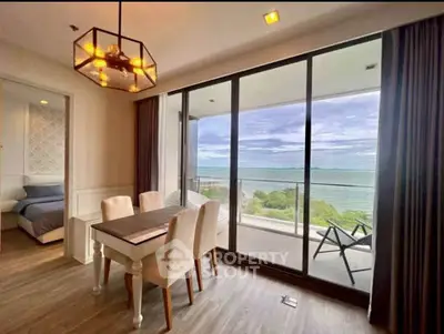 Stunning ocean view from modern dining area with elegant lighting and spacious balcony.