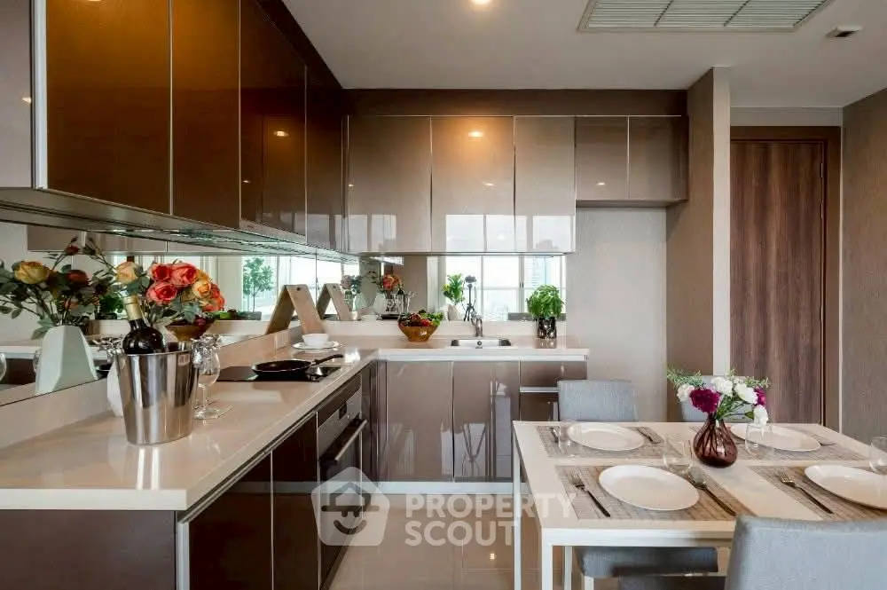Modern kitchen with sleek cabinets and dining area, featuring elegant decor and ample natural light.