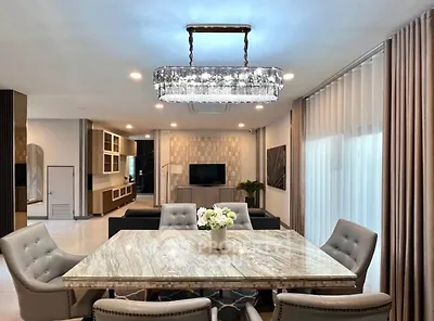 Luxurious open-plan living room with elegant dining area and modern chandelier.