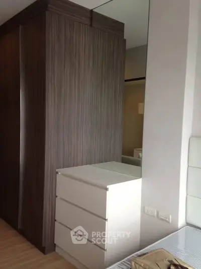 Modern bedroom with sleek wardrobe and dresser, perfect for stylish living.