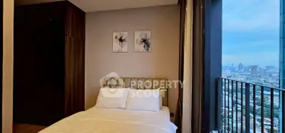 Cozy bedroom with city view and balcony access in modern apartment.