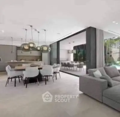 Luxurious open-plan living room with modern dining area and pool view