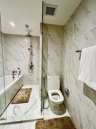 Luxurious marble bathroom with modern shower and bathtub, perfect for relaxation.