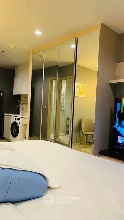 Modern bedroom with mirrored closet and in-room washing machine