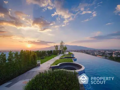 Luxurious rooftop infinity pool with stunning sunset view over the cityscape and mountains.