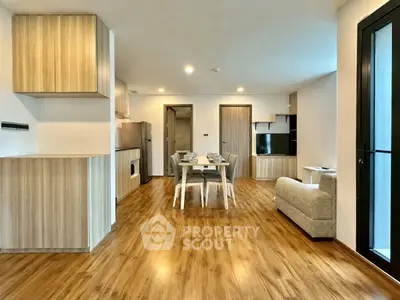Modern open-plan living room with wooden flooring and stylish furniture