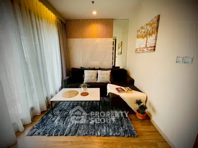 Stylish living room with cozy sofa, elegant decor, and large window for natural light.