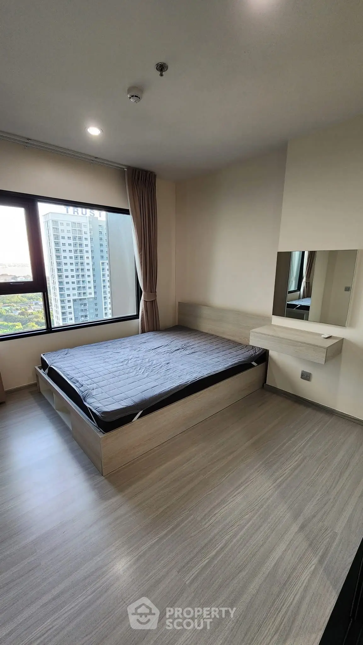 Modern bedroom with large window and city view, featuring a minimalist design and sleek flooring.