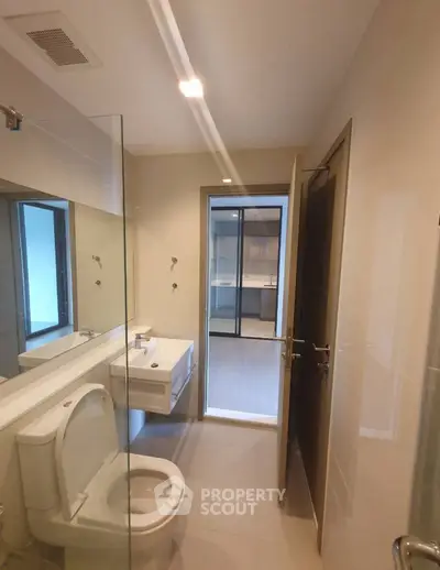 Modern bathroom with glass shower and sleek fixtures in a contemporary apartment.