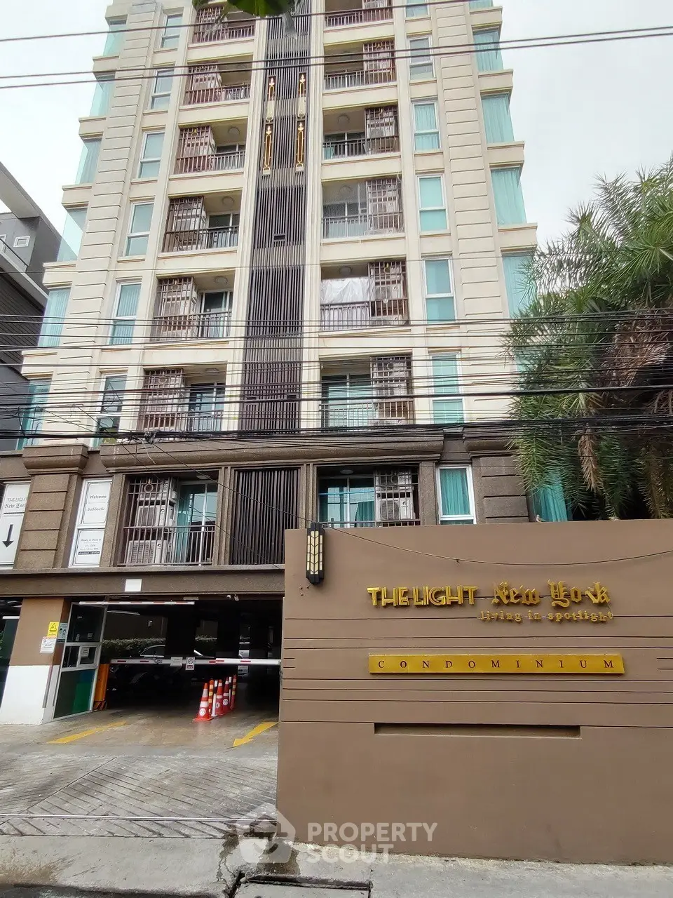 Modern condominium building exterior with elegant design and secure parking area.