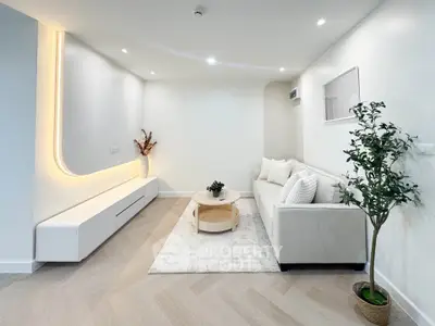 Modern living room with sleek design, featuring a cozy sofa, stylish lighting, and elegant decor.