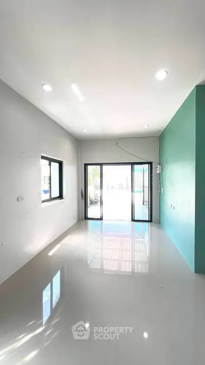 Spacious modern living room with large windows and glossy floor tiles