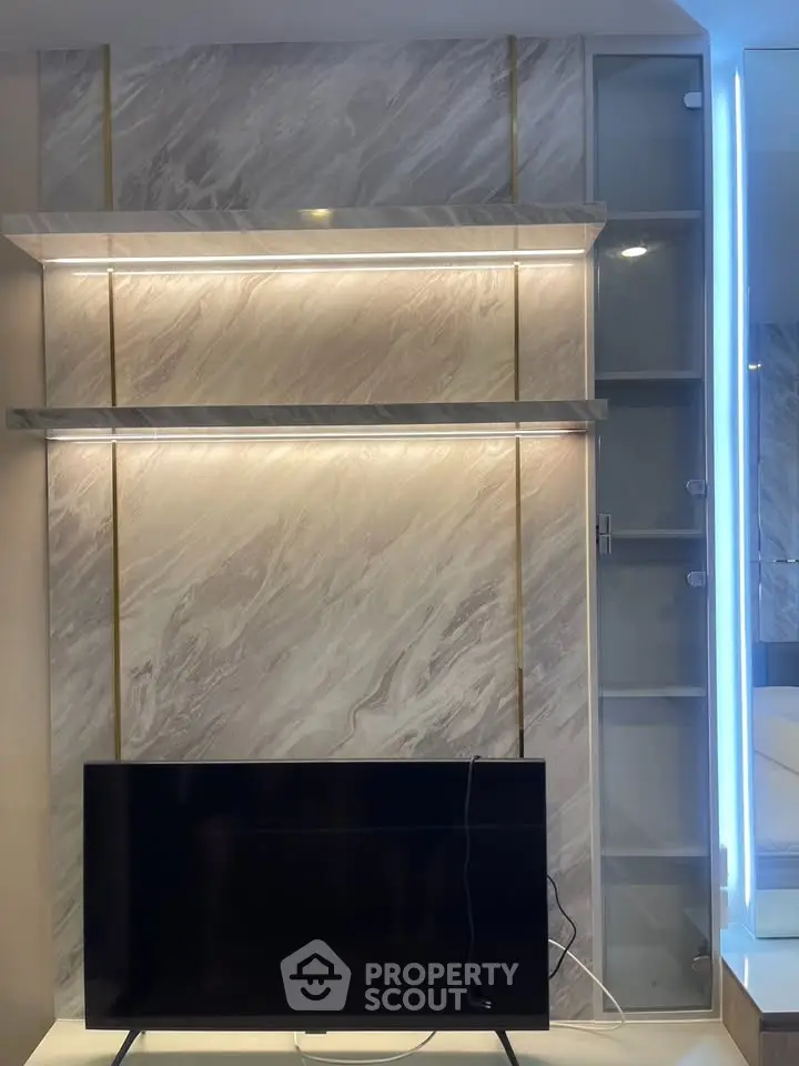 Modern living room with sleek TV setup and elegant marble wall design