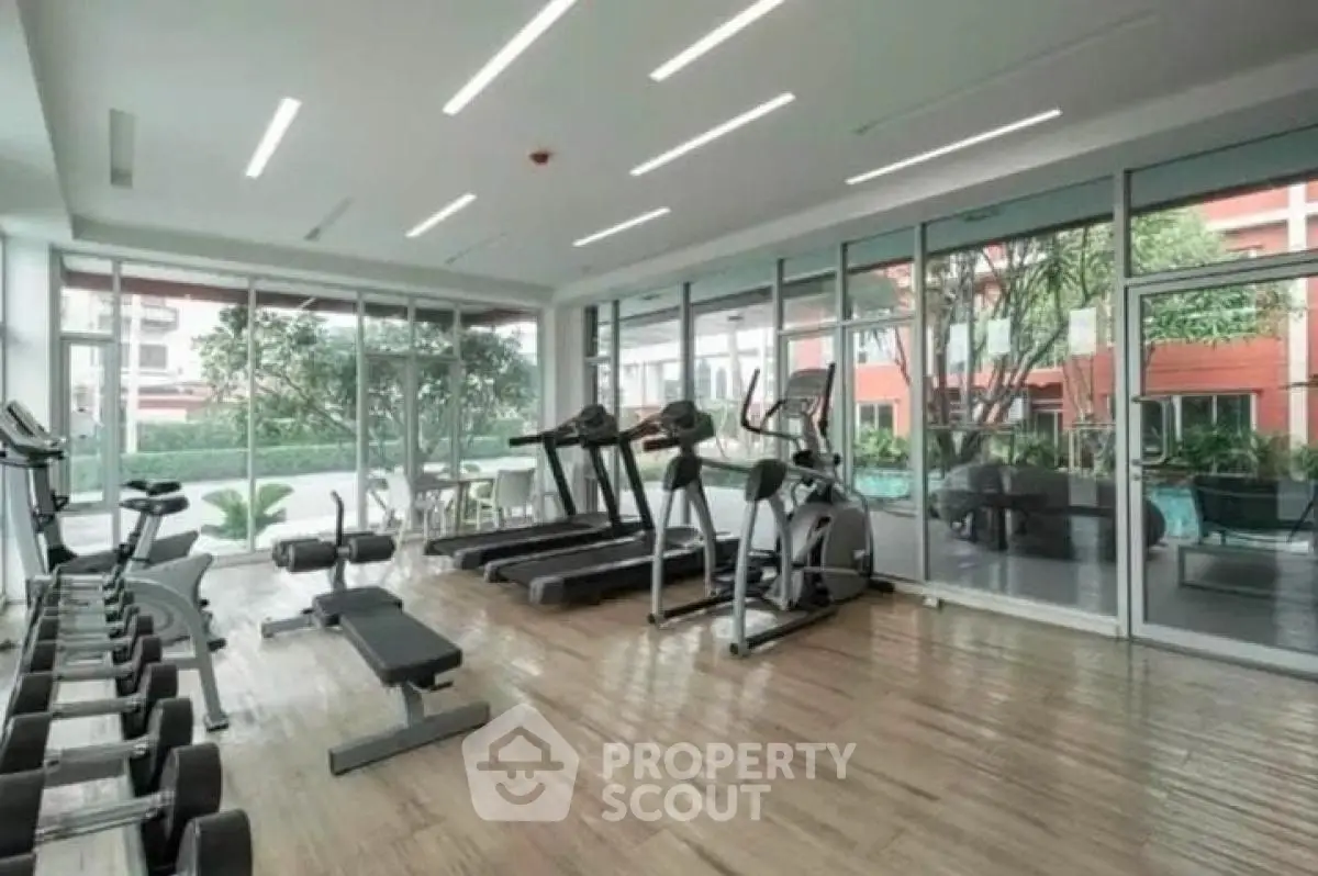 Modern gym with state-of-the-art equipment and large windows offering a scenic view.