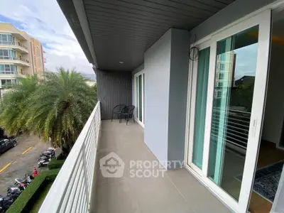 Spacious balcony with modern design and scenic view in a contemporary apartment building.