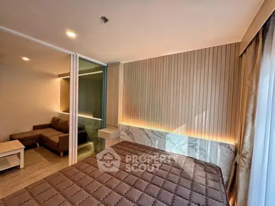 Modern bedroom with stylish wood paneling and cozy living area in a contemporary apartment.