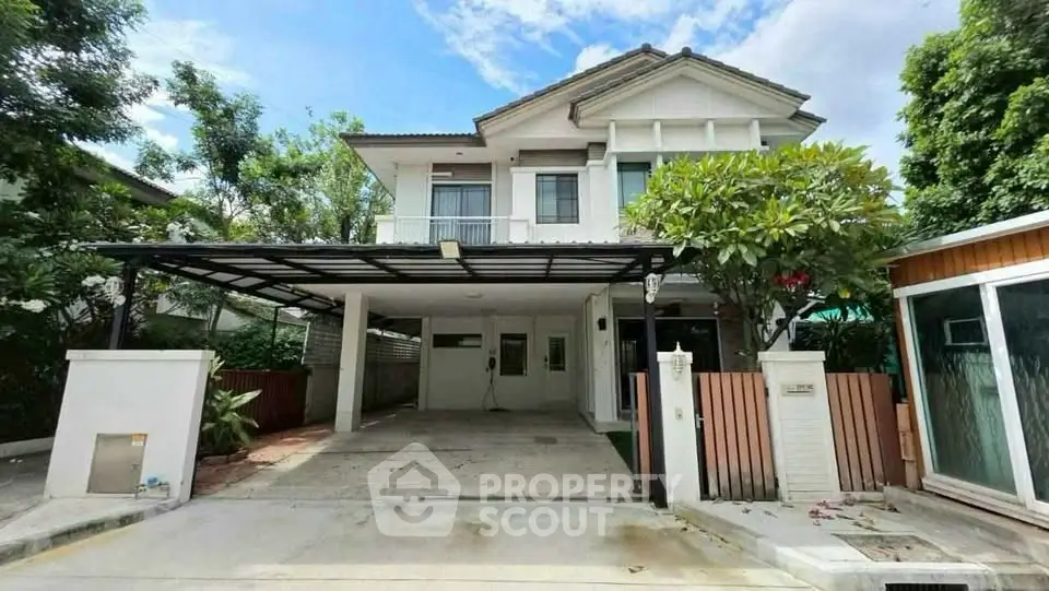 Charming two-story house with spacious driveway and lush greenery in a serene neighborhood.