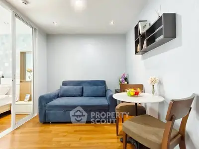 Cozy living room with blue sofa and dining area in modern apartment