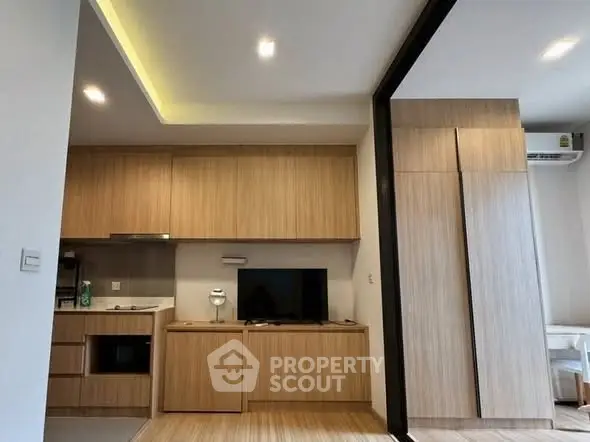 Modern living room with sleek wooden cabinetry and integrated TV unit