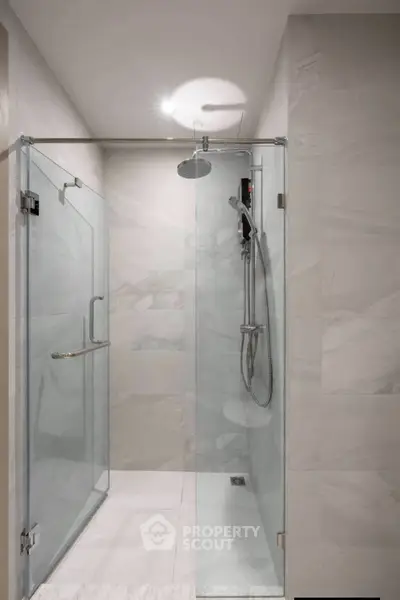 Modern bathroom with sleek glass shower enclosure and elegant fixtures.