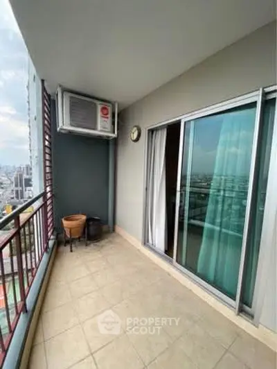 Spacious balcony with city view and sliding glass doors in modern apartment