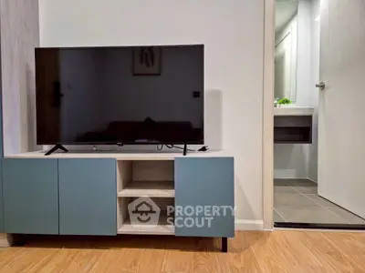 Modern living room with sleek TV stand and glimpse of stylish bathroom