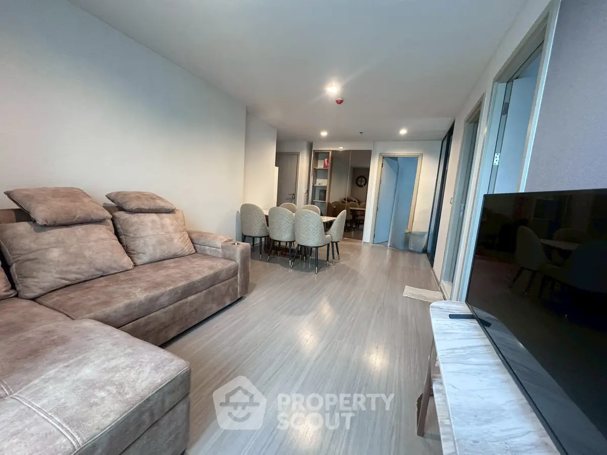 Spacious living room with modern decor and comfortable seating in a stylish apartment.