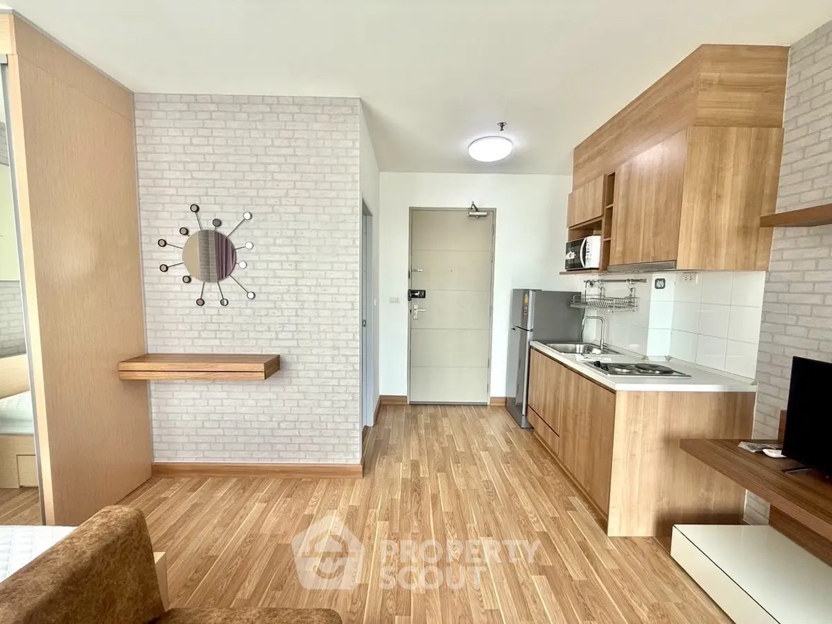 Modern apartment interior with wooden flooring and compact kitchen