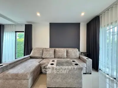 Modern living room with stylish gray sectional sofa and large windows