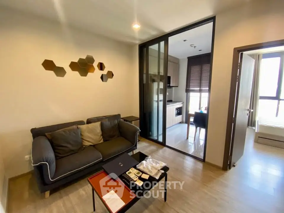 Modern living room with cozy sofa and stylish kitchen in open layout apartment.