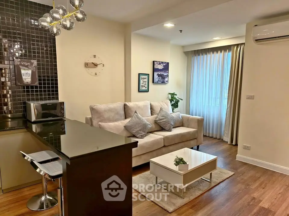 Modern living room with stylish decor and open kitchen layout in a cozy apartment.