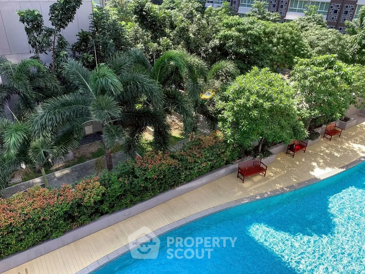 Luxurious poolside view with lush greenery and serene ambiance in a modern residential complex.