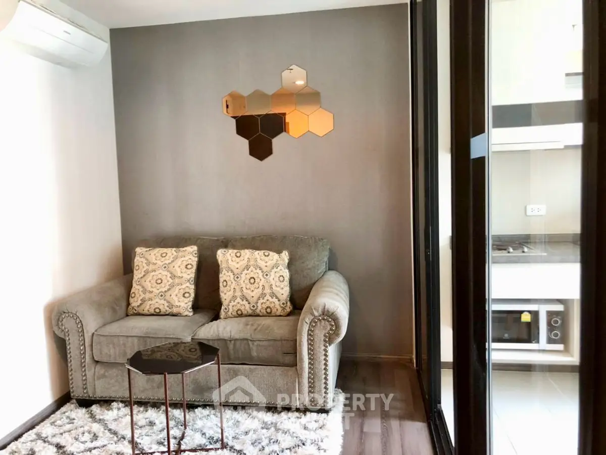 Cozy living room with modern decor and adjacent kitchen area in a stylish apartment.
