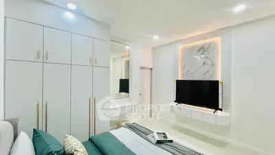Modern bedroom with sleek design, built-in wardrobe, and mounted TV for luxury living.