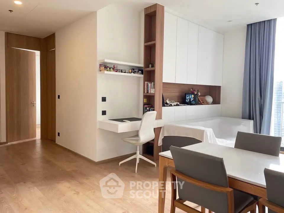 Modern living room with study area and dining set, featuring sleek wooden flooring and large window view.