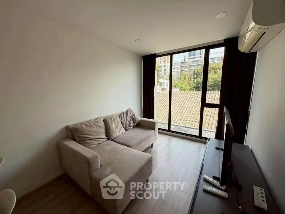 Modern living room with large window and cozy sofa in urban apartment