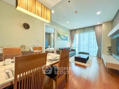 Spacious modern living room with dining area and large windows in a stylish apartment.