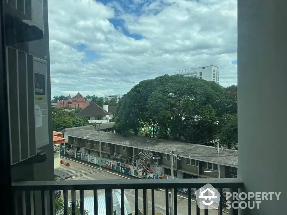 Scenic urban view from balcony with lush greenery and cityscape