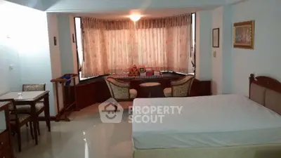Spacious studio apartment with large windows and elegant furnishings