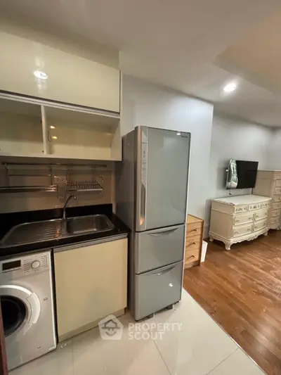 Compact kitchen with modern appliances and cozy living area