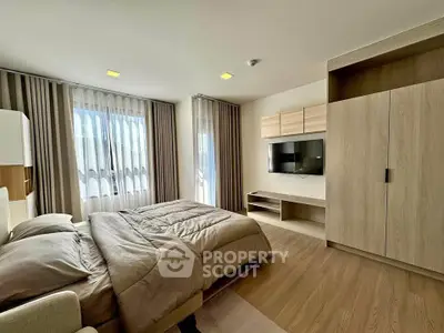 Modern bedroom with sleek design, featuring a large window and built-in wardrobe.