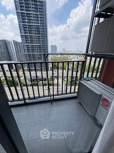 Modern balcony with city view in high-rise apartment, featuring sleek railing and tiled flooring.