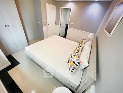 Modern bedroom with stylish decor and ample natural light, featuring a comfortable bed and sleek furnishings.